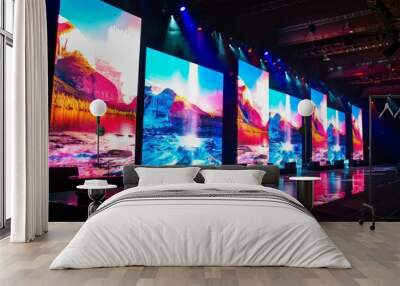 A modern stage set for a performance or event, with multiple large screens displaying vibrant landscapes and dynamic lighting illuminating the scene. Wall mural