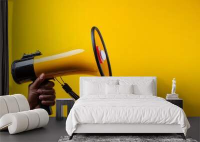 Hand holding megaphone, marketing and sales, yellow background Wall mural