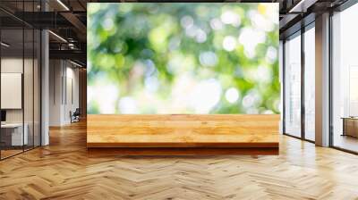 Empty wooden table with bokeh abstract green background. Wall mural