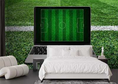 Laptop on soccer grass field background. Wall mural