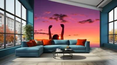 Silhouette of young woman at sunset on sea background. Wall mural