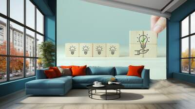 suggestion and consulting concept. new idea, solution. putting wooden cubes with light bulb on hand  Wall mural