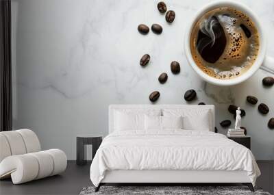 top down view of a steaming cup of black coffee on a white marble surface, surrounded by coffee beans Wall mural