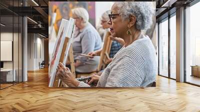 A diverse group of older adults painting on easels in an art class Wall mural