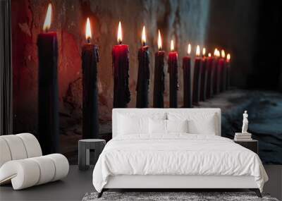 A row of ominous, black candles with red wax drippings, burning low on a dusty altar, with a shadowy, decrepit background Wall mural