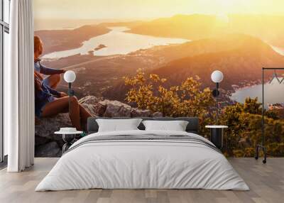 Happy couple watching the sunset in the mountains Wall mural