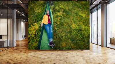 Woman resting in hammock outdoors. Sleeping outdoors. Wall mural