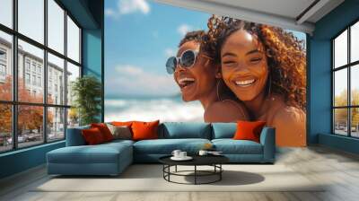 LGBTQ, gay and lesbian black women enjoying a piggyback ride and fun at beach in summer. Friends, dating and trust with female and her girlfriend on holiday, vacation or travel by the coast Stock Phot Wall mural