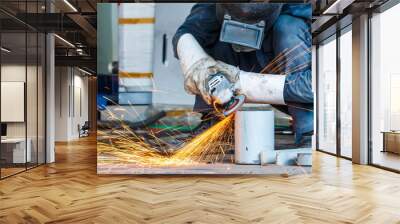 Worker cutting metal with grinder. Sparks while grinding iron Wall mural