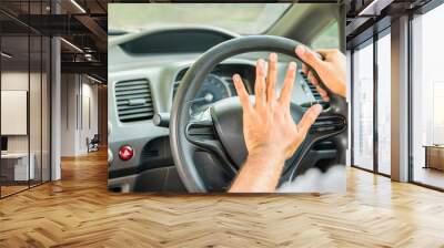 Closeup hands pushing on steering wheel honking horn in his car. Safety concept Wall mural