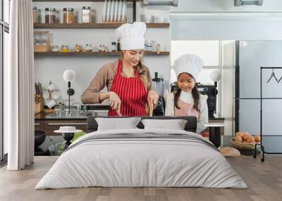 Happy moment asian mother and daughter cooking breakfast salad in the kitchen. Mom and daughter asian family having fun preparing healthy food vegetable. Positive parent and kid nice relationship Wall mural