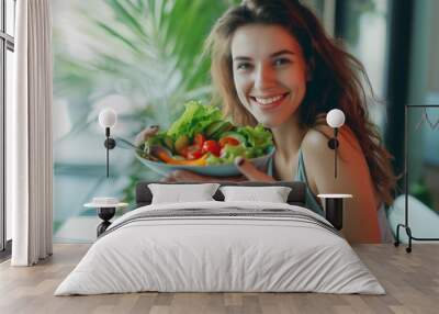 Happy beautiful young woman eating salad at home. Vegan, healthy lifestyle concept Wall mural