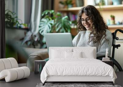 Smiling disability woman in wheelchair work on laptop at home. Technology and lifestyle concept Wall mural