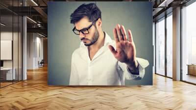 Annoyed angry man with bad attitude giving talk to hand gesture Wall mural