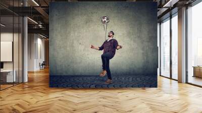 Full length of a young guy juggling a football Wall mural