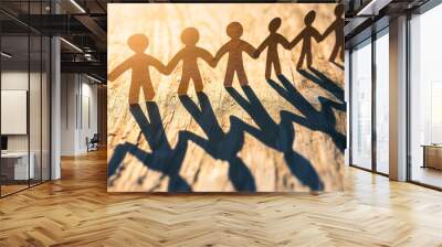 Paper human chain holding hands together and standing in bright light, teamwork and success concep Wall mural