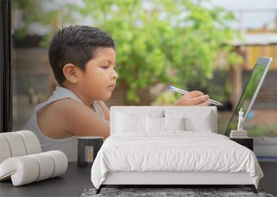 Latino boy using a laptop. Hispanic infant looking at a computer screen. Online education, preschool, new generation. Brunette baby. Little netizen. Small business. Blue pencil. Wall mural