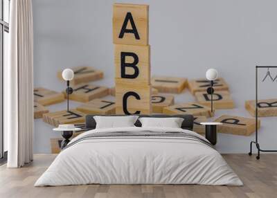 stack of square wooden blocks with the letters ABC surrounded by square wooden letters on a white background  Wall mural