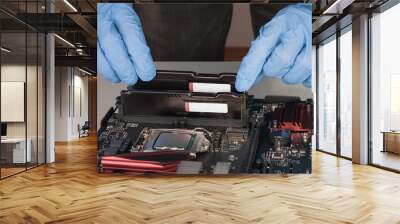 Close up of man hands with gloves installing Ram DDR4 memory module in slot on motherboard Wall mural