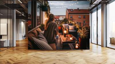 woman sitting on her cosy balcony with fairy lights in the evening light and looks at the city, generative ai Wall mural