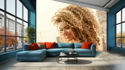 Gorgeous and happy woman portrait with beautiful curly hair smiling Wall mural