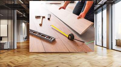 man installing new laminated wooden floor Wall mural