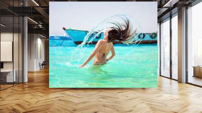 Young brunette jumping out of turquoise water of Red Sea, Egypt Wall mural