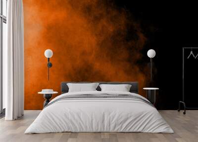 Abstract orange powder explosion on black  background. Freeze motion of orange  dust particles splash. Wall mural