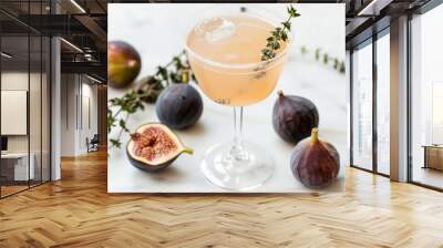 A glass of fig and thyme cocktail with fresh figs on a white background Wall mural