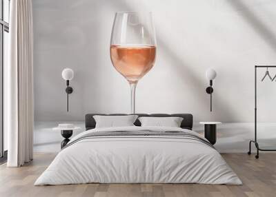 A glass of rose wine with light reflections on a white background Wall mural