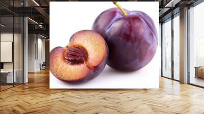 A whole plum with a slice showing the inside on a white background Wall mural