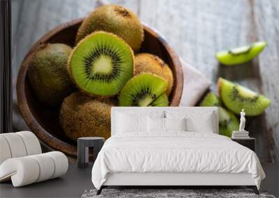 Fresh kiwi fruit in the bowl on wooden background Wall mural