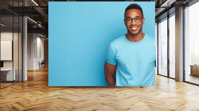 African american man waring blue t-shirt and glasses isolated on blue background Wall mural