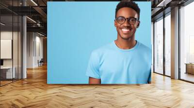 African american man waring blue t-shirt and glasses isolated on blue background Wall mural