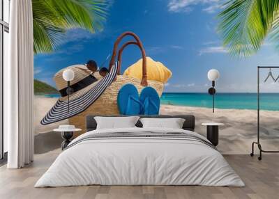 summer bag on tropical sand beach vacation accessories hat towel and flip flops with leaves palm and blue sea Wall mural