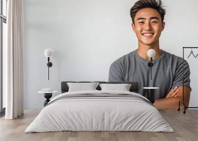 A smiling young Asian man, wearing a casual t-shirt and jeans, isolated on a white background Wall mural