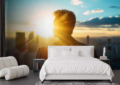 Silhouette of business man looking at the city from the rooftop. Wall mural