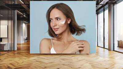 beautiful model with moistuser face cream on her cheek Wall mural