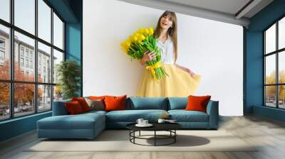 young happy woman with yellow tulips Wall mural