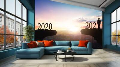 2021 concept: Silhouette of year 2021 and businessman  on mountain  with city sunset  background Wall mural