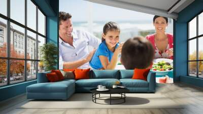 Family eating lunch at table on sunny patio Wall mural