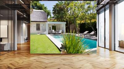 Lawn chairs and swimming pool in backyard Wall mural