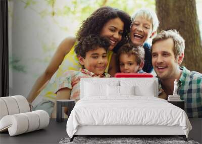 Multi-generation family taking selfie with camera phone in woods Wall mural