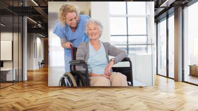 Nurse and aging patient smiling in hospital corridor Wall mural