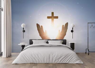 Brightly shining sunlight and Silhouette of cross in human hand Wall mural