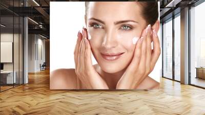 beautiful model applying cosmetic cream treatmen on her face Wall mural