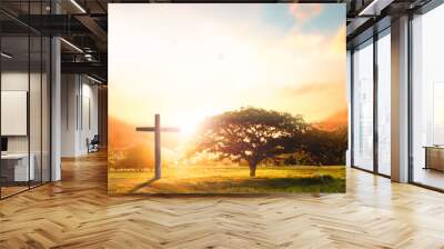 Concept conceptual black cross religion symbol silhouette in grass over sunset or sunrise sky Wall mural