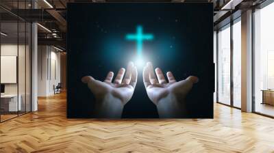 Easter concept, Open hands  holding a glowing cross , symbol of Christian faith. Wall mural