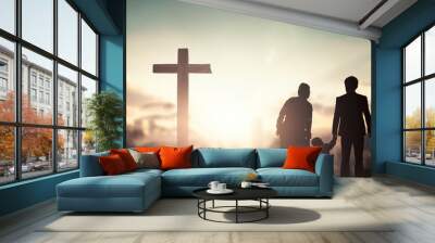 Family worship and praise concept: family praying before the cross Wall mural