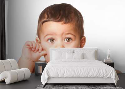 Cute baby infant with big green eyes thumb on cheek on white Wall mural